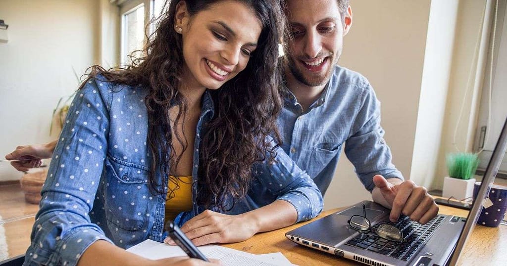 Happy couple budgeting to take control of their finances