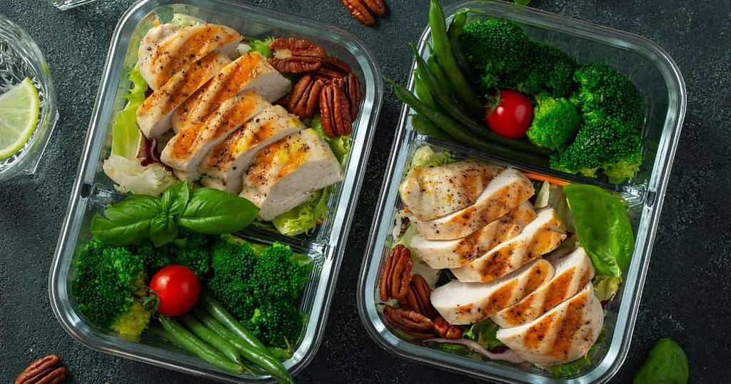 Healthy homemade lunches in reusable containers with salads, wraps, and fruit to show how making your own lunch saves money