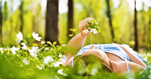 A Fresh Start for Your Finances – Reset, Reflect and Rebuild. Woman relaxing among white flowers in a sunlit garden, representing a fresh start and renewed financial wellbeing.