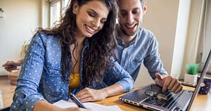 Happy couple budgeting to take control of their finances